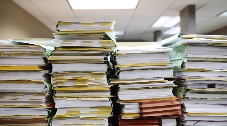 vaga de garagem do meu apartamento foi a leilão: Pilhas de documentos e pastas organizados em escritório para consulta