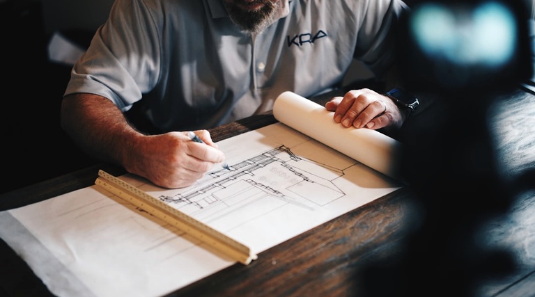 Advogado especialista em construção civil: análise técnica advogado especialista em construção civil: Profissional analisa planta técnica e documenta demandas jurídicas em projeto