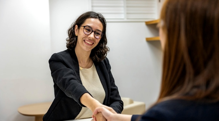 Advogado para compra de imóvel de alto valor: profissional de terno cumprimentando cliente em escritório