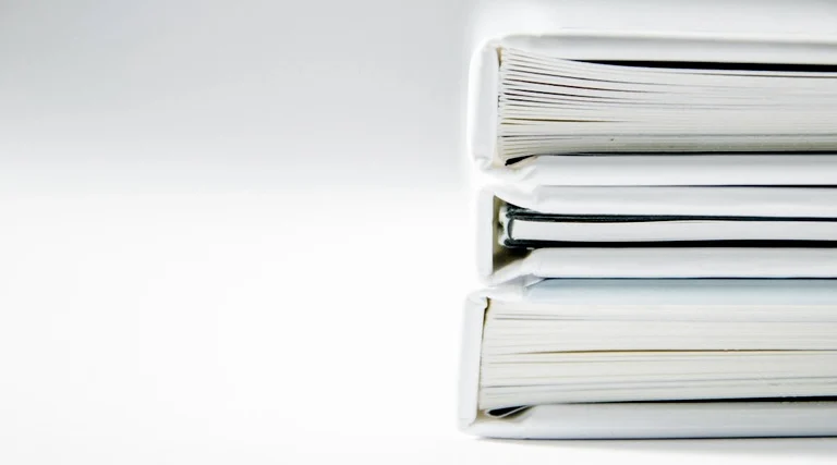 riscos de comprar imovel em inventario: Pilha de pastas organizacionais com documentos de inventário empilhados sobre mesa