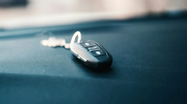 Chave de carro e golpe do falso intermediário Golpe do falso intermediário na venda de carro: chave automotiva sobre painel do veículo