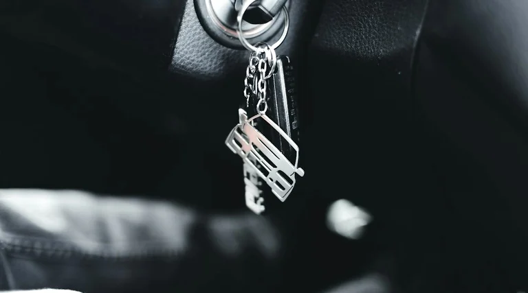 Chaveiro na ignição de carro usado Carro usado com defeito comprado na loja: chaveiro com pingente de carro pendurado na ignição de veículo