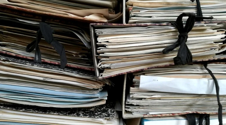 Golpe do falso intermediário na venda de carro: Pilhas de processos e documentos jurídicos amarrados com fitas